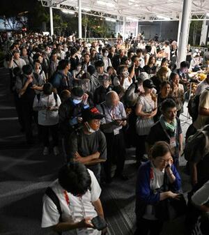 大阪メトロ中央線が運転見合わせとなり、万博会場で運転再開を待つ大勢の人たち=13日深夜、大阪市此花区の夢洲