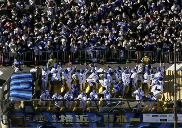 優勝パレードに詰めかけたファンに手を振るＤｅＮＡの選手ら（手前）＝１１月３０日午前、横浜市（共同通信社ヘリから）