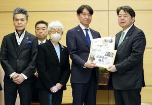 林官房長官に署名を手渡す「横田めぐみさんとの再会を誓う同級生の会」の池田正樹代表(右から2人目)。同3人目は早紀江さん=10日、首相官邸