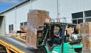 フォークリフトで運ばれるパレット積みの荷物(コメリ提供)