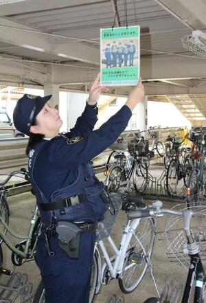 自身がデザインしたポスターを手に、自転車の鍵かけを呼びかける小田いづみ巡査部長＝五泉市駅前１