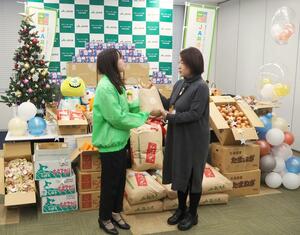 JA共済連新潟からコメなどを寄付された県フードバンク連絡協議会の山下浩子会長(右)=新潟市中央区